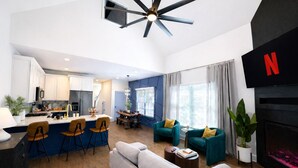 Una sala de estar moderna con un sofá, sillas, una mesa de centro, un televisor y una chimenea.