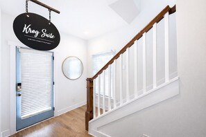 Eine Treppe mit hölzernen Geländern und einem schwarzen Schild, das von der Decke hängt.