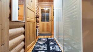 Ein Holzhaus-Interieur mit Holztür, Glastür und einem gemusterten Teppich.