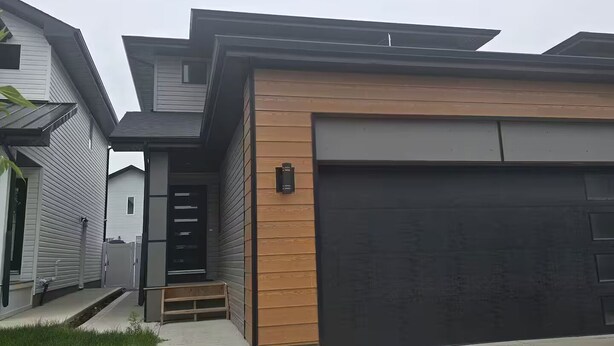 A modern two-story house with a garage, a covered porch, and a small front yard. - Oshmild Suites, 5 mins to various shops and Cinema (Saskatoon)