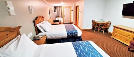 Een hotelkamer met twee bedden, een bureau, een stoel, een dressoir en een televisie.