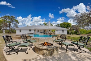 A house with a swimming pool, outdoor seating, and a fire pit. - Rivers Oaks-the Ranch House Pool & Hot-tub! (Fredericksburg)