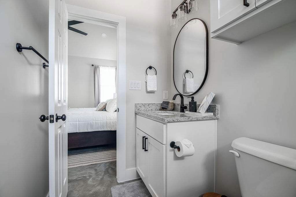A modern bathroom with a toilet, sink, and mirror.