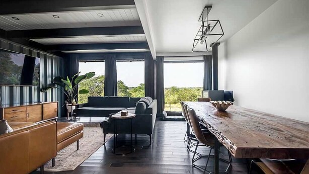 Una sala de estar moderna con una mesa de comedor de madera, un sofá y una mesa de centro.