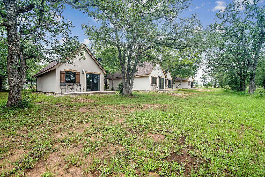 A property with two detached houses, each with a front porch and a small garden area.