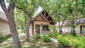 Un chalet rustique avec un toit en pente, entouré d’arbres majestueux et d’un jardin bien entretenu.