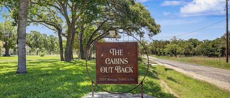 Un panneau indiquant « The Cabins Out Back », situé au 2557, chemin Knopp School.
