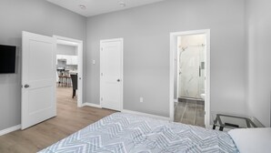 Une chambre avec un lit, une douche et une cuisine à l’arrière-plan.