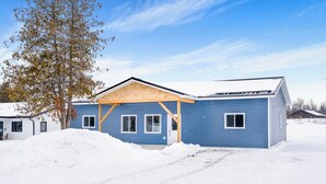A blue single-story house with a wooden porch and a snow-covered yard. - 5 minutes to Rice Lake, brand new home, clean and cozy! (Roseneath)