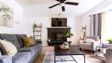 Una Smart TV, una chimenea, libros, un reproductor estéreo