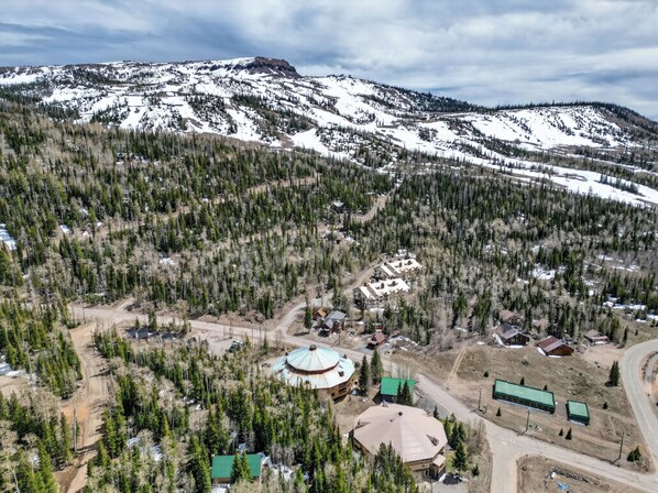 A mountainous area with a small settlement featuring several buildings, including a prominent circular structure with a green roof. - Sleeps 6, Full Kitchen, Separate King Primary Bedroom (Brian Head)