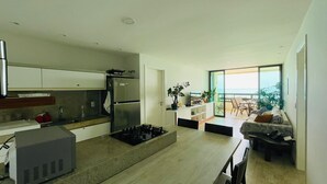 Una cocina moderna con estufa integrada, refrigerador y comedor con mesa y sillas.
