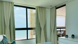 Un dormitorio con cama, cómoda y vista a la playa.