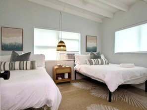 A bedroom with two beds, a nightstand, a hanging light, and artwork on the walls. - 2 Bedroom on the Barrier Island. Walk to the Beach (Fort Lauderdale)