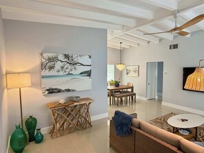 A modern living room with a sofa, a dining table, and a ceiling fan. - 3 Bedroom on the Barrier Island. Walk to the Beach (Fort Lauderdale)