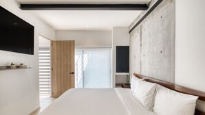 Una camera da letto moderna con un letto grande, una testiera in legno e una TV a parete.