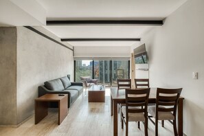 Ein modernes Wohnzimmer mit einer Couch, einem Couchtisch und einem Essbereich mit Stühlen.