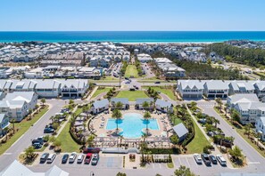 Resort com piscina central, vários edifícios e vista para a praia.