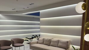 A modern living room with a sofa, two armchairs, a coffee table, and a floor lamp.
