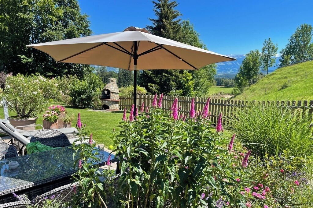 A garden with a patio area, a table, and an umbrella.
