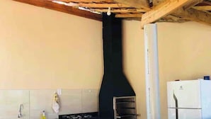 A kitchen with a black countertop, a stove, and a white refrigerator.