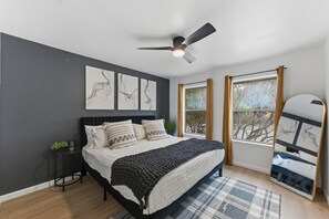 A bedroom with a bed, a ceiling fan, a window with curtains, and artwork on the wall. - Spacious Retreat Near Downtown (Austin)