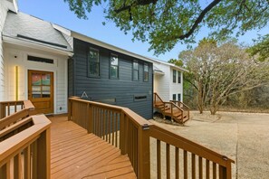 A two-story house with a wooden deck and a staircase leading to the second floor. - Spacious Retreat Near Downtown (Austin)