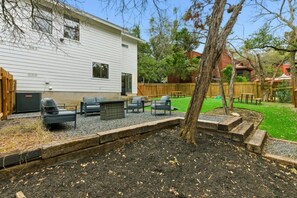 A residential backyard with a patio area, outdoor furniture, and a wooden deck. - Spacious Retreat Near Downtown (Austin)