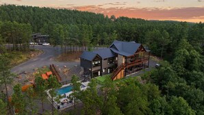 Un chalet moderne doté d’une grande terrasse, d’une piscine et surplombant une forêt.