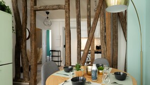 Comedor con una mesa redonda dispuesta para cuatro personas, rodeado de vigas de madera.