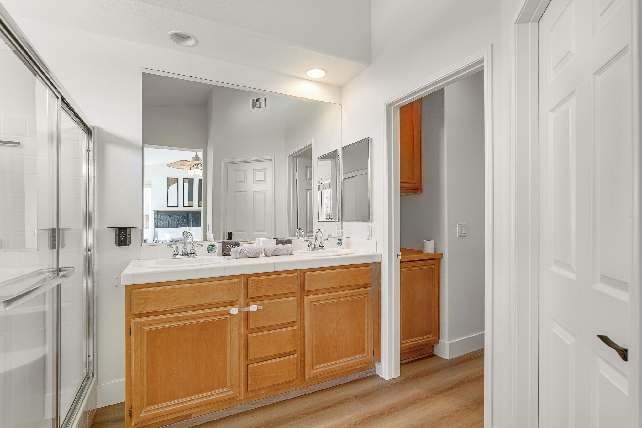 Une salle de bain moderne dotée d’un grand meuble-lavabo, d’une douche à parois de verre et d’un dressing.