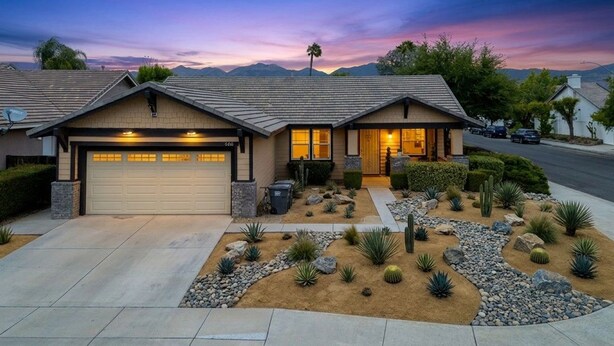 A two-story house with a garage, a landscaped garden with cacti and rocks, and a mountain backdrop. - Nectar Nest, Video Tour, Pool, Spa, Fire Pit Arcade Game Room, King Master Suite (Hemet)
