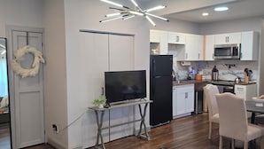 Una cocina moderna con armarios blancos, un refrigerador negro y un microondas.