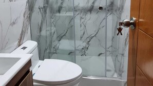 A bathroom with a marble shower enclosure, a toilet, and a sink. - Cusco Apartment, Prime Location (Cusco)