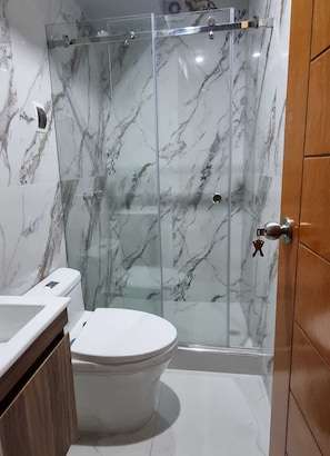A bathroom with a marble shower enclosure, a toilet, and a sink. - Cusco Apartment, Prime Location (Cusco)