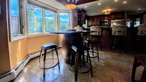 A kitchen with a large window, wooden bar stools, and a hanging light fixture. - Fv49 Wow Stunning Single Level Home Next to Golf Course and Mt Washington Hotel (Bretton Woods)