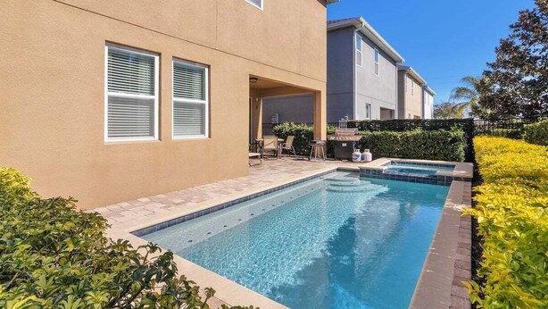 A modern two-story house with a swimming pool, a patio with outdoor furniture, and a well-maintained garden. - 480-7-ld-large Luxury (Kissimmee)