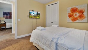 A hotel room with a bed, a painting, and a television on the wall. - 480-7-ld-large Luxury (Kissimmee)