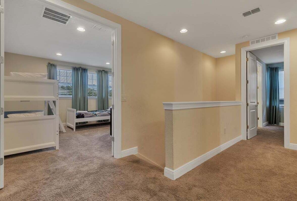 A bedroom with a bunk bed, a walk-in closet, and a door leading to another room.