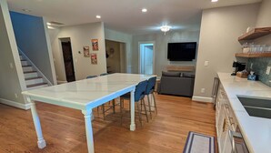 A spacious kitchen with a dining area, wooden flooring, and a modern design. - Stylish Durham Retreat - Walkable, Sleeps 6 (Durham)