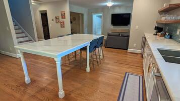 Una cocina amplia con comedor, pisos de madera y diseño moderno.