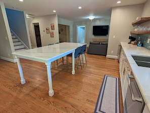 A spacious kitchen with a dining area, wooden flooring, and a modern design. - Stylish Durham Retreat - Walkable, Sleeps 6 (Durham)