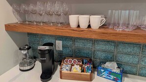 A kitchen counter with a coffee maker, a box of tissues, and a tray of snacks. - Stylish Durham Retreat - Walkable, Sleeps 6 (Durham)