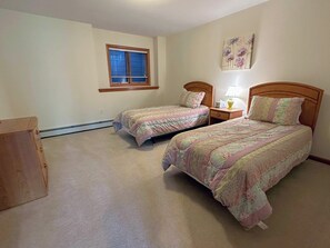 A bedroom with two beds, a window, a nightstand, and a wall decoration. - SH3 Luxurious Stonehill Townhouse in Bretton Woods (Bretton Woods)
