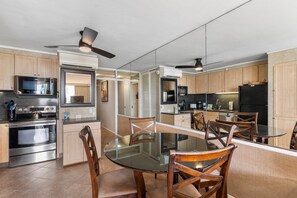 Una cocina moderna con armarios de madera, una mesa de comedor de cristal y electrodomésticos integrados.