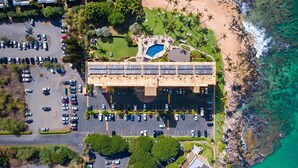 An aerial view of a hotel with a parking lot, a pool area, and a beach. - Mana Kai 314 (Kihei)
