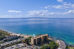 Un hotel costero con vista al océano, zonas de estacionamiento y una playa.