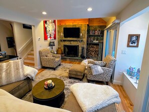 A cozy living room with patterned furniture, a fireplace, and a television. - Rb20 Luxury Townhome in Bretton Woods (Bretton Woods)