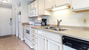 A kitchen with white cabinets, a microwave, a coffee maker, and a dishwasher. - Beautiful 2 Bedroom Lakeside Condo at The Shores 5677 (Williamsburg)