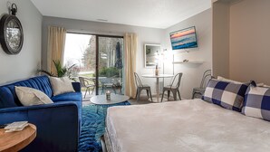 Et hotelværelse med en seng, en sofa, et spisebord og en stol.